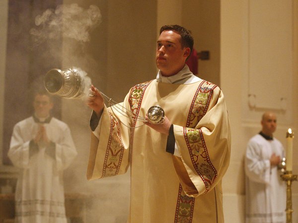 Khi bỏ hương vào bình hương, linh mục ngồi hay đứng?